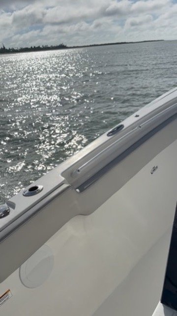 Looking over the boat's gunwale at sunlight sparkling on the water